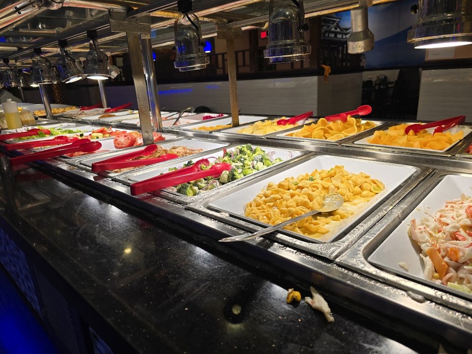 A salad bar with rows of fresh dishes.